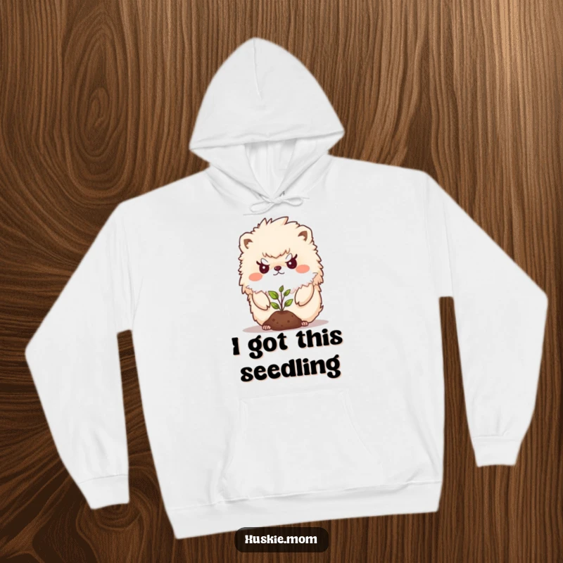 Funny Hoodie showcasing a fluffy animal with a determined gaze protecting a delicate seedling, a symbol of loving care.