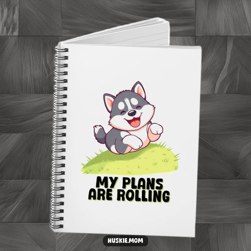 Funny notebook with a gleeful husky puppy tumbling head over paws down a grassy hill, ideal for jotting down notes and creative ideas.