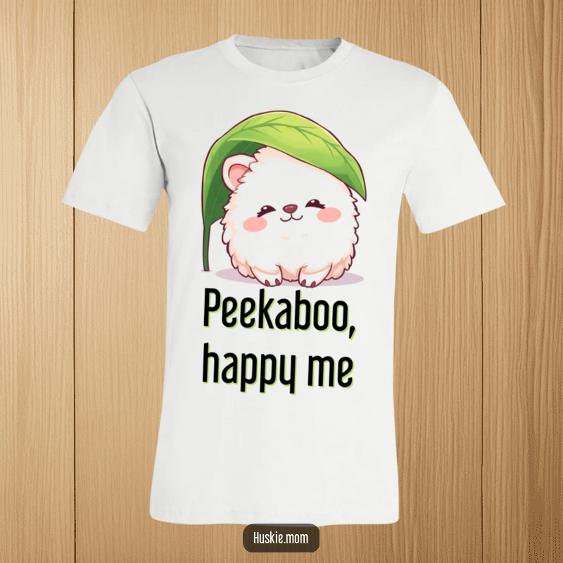 Funny fluffy animal t-shirt showing a creature with a peaceful smile peeking playfully from beneath a leaf, radiating gentle humor.