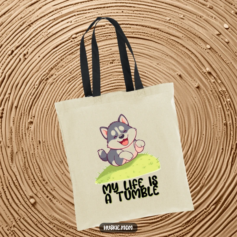 Funny tote bag featuring a gleeful husky puppy tumbling head over paws down a grassy hill, celebrating canine joy and adventure.